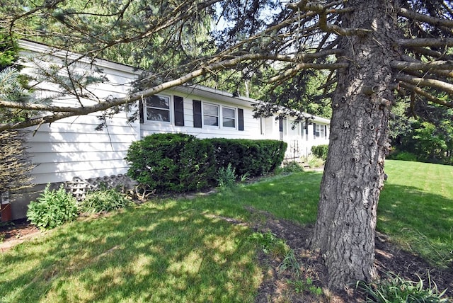 view of side of home with a yard