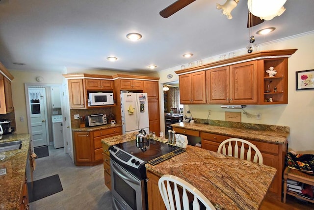 kitchen featuring ceiling fan, light stone counters, white appliances, and decorative backsplash