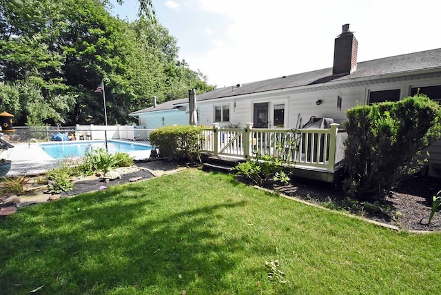 exterior space featuring a swimming pool side deck and a lawn