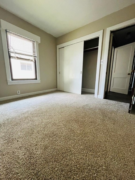 unfurnished bedroom featuring carpet floors and a closet