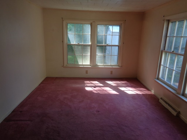 carpeted spare room featuring plenty of natural light and baseboard heating