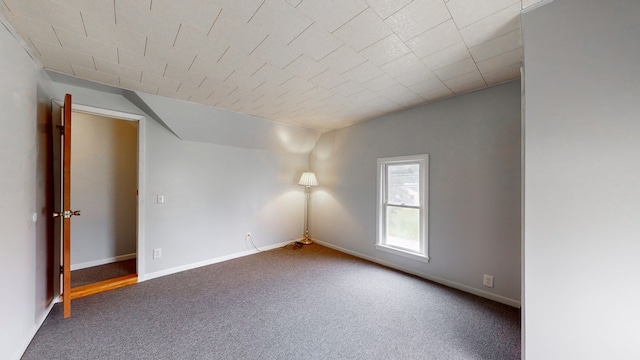 spare room featuring carpet floors and vaulted ceiling