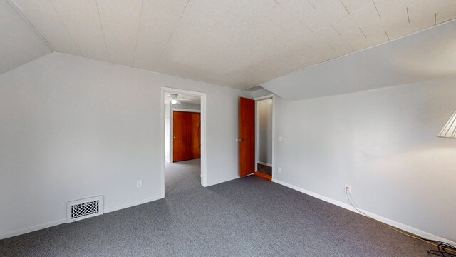 bonus room featuring vaulted ceiling and dark colored carpet