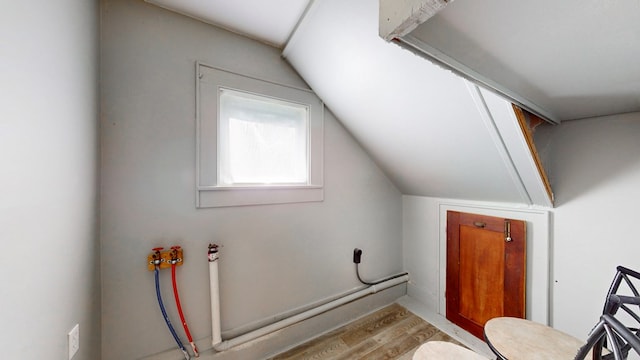 bathroom with vaulted ceiling and hardwood / wood-style floors