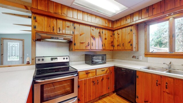 kitchen featuring sink, light hardwood / wood-style flooring, and black appliances