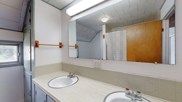 bathroom with vanity and lofted ceiling