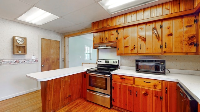 kitchen featuring a paneled ceiling, kitchen peninsula, light wood-type flooring, and black appliances