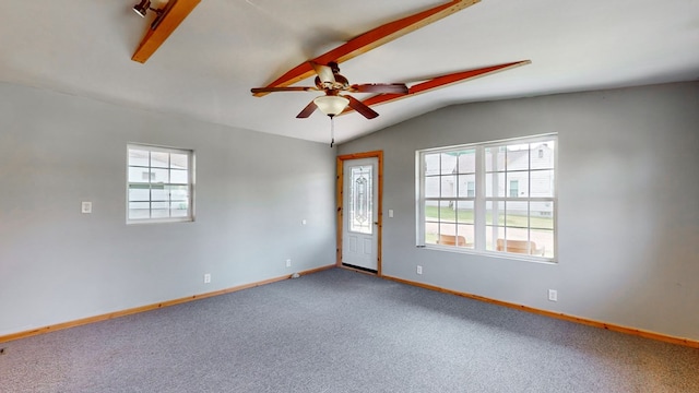 carpeted spare room featuring ceiling fan and lofted ceiling with beams