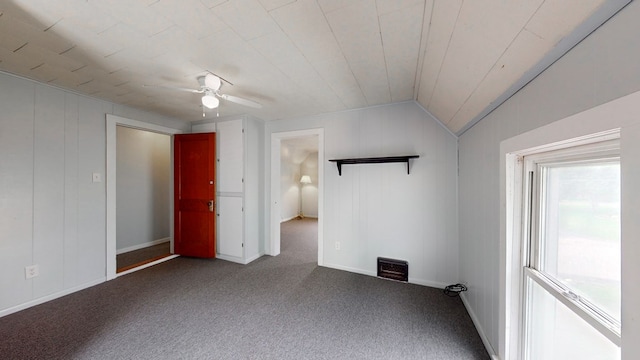 carpeted spare room featuring vaulted ceiling and ceiling fan