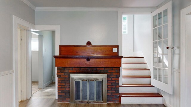 living room with crown molding, a fireplace, and hardwood / wood-style flooring