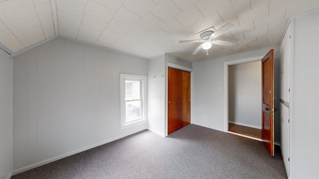 unfurnished bedroom with vaulted ceiling, a closet, ceiling fan, and carpet flooring