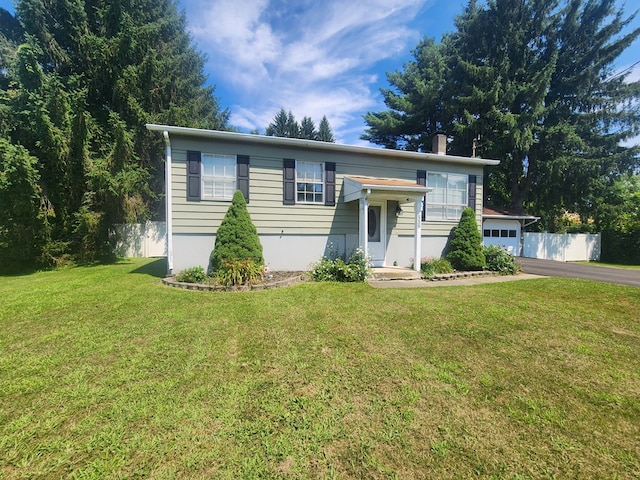 bi-level home with a garage and a front lawn