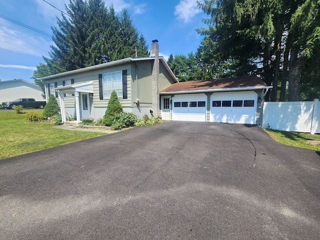 split foyer home featuring a garage and a front lawn