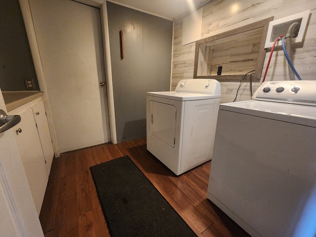 laundry area featuring dark hardwood / wood-style floors, independent washer and dryer, and wood walls