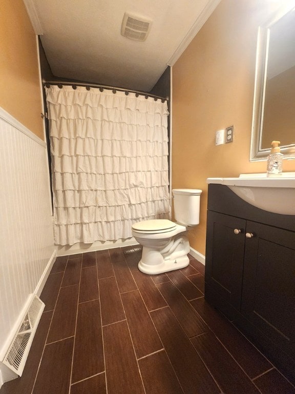 bathroom featuring ornamental molding, vanity, and toilet