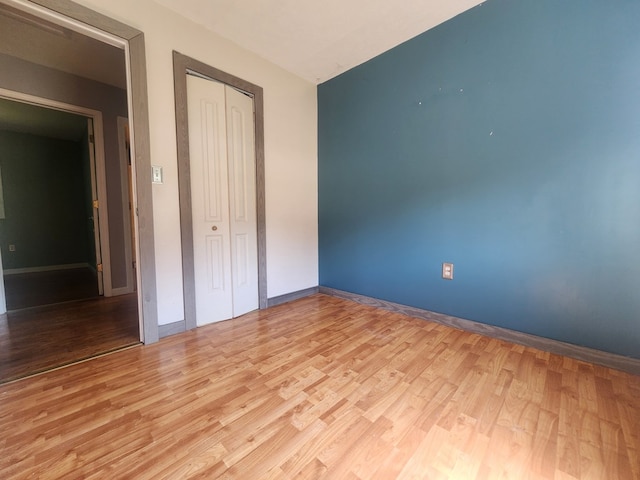 unfurnished bedroom with a closet and light hardwood / wood-style flooring