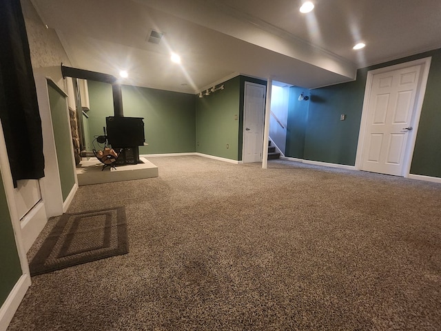 basement with carpet and a wood stove