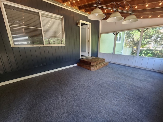 unfurnished sunroom with lofted ceiling with beams