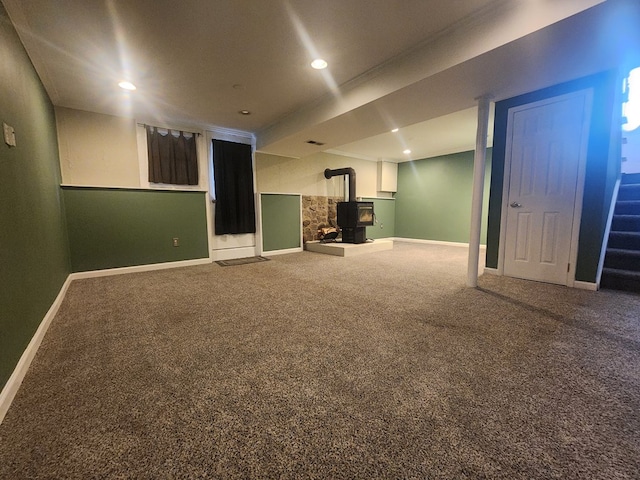 basement with carpet floors and a wood stove