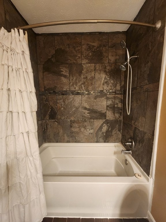 bathroom featuring shower / tub combo and a textured ceiling