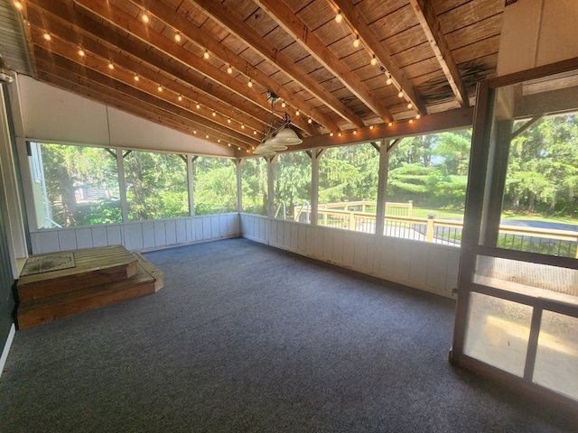 unfurnished sunroom with vaulted ceiling, wooden ceiling, and rail lighting