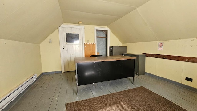 interior space with hardwood / wood-style flooring, a baseboard radiator, and lofted ceiling