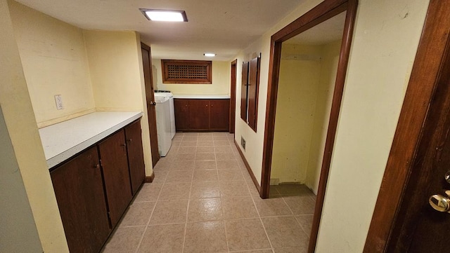 hall featuring washer / clothes dryer and light tile patterned flooring