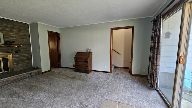 unfurnished bedroom with ornamental molding, light carpet, a textured ceiling, and a fireplace