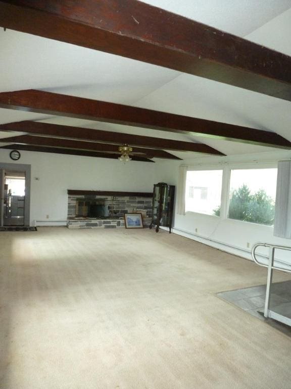 unfurnished living room with a baseboard heating unit, lofted ceiling with beams, and carpet