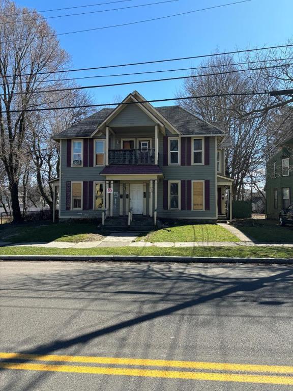 colonial house with a front yard and a balcony