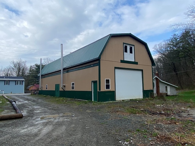 view of side of home with a garage and an outbuilding