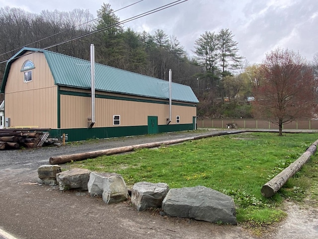 view of property exterior with a yard and an outdoor structure