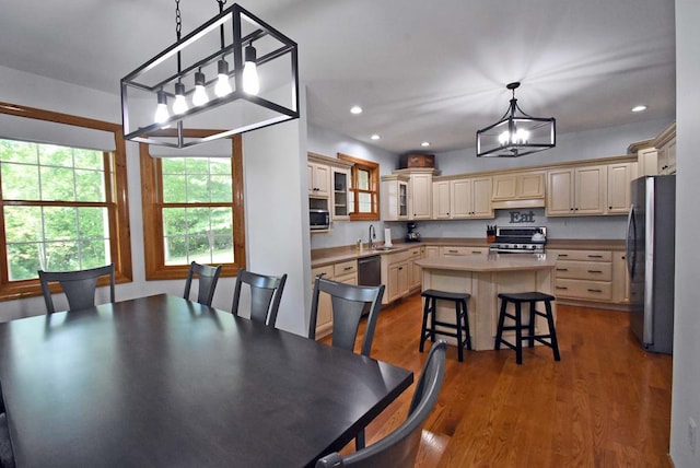 dining space with an inviting chandelier, sink, and wood-type flooring