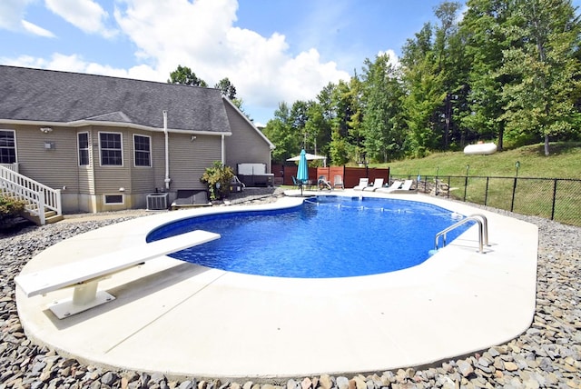 view of swimming pool with a yard, central AC, a diving board, and a patio area