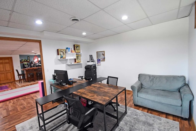 home office with wood-type flooring and a drop ceiling