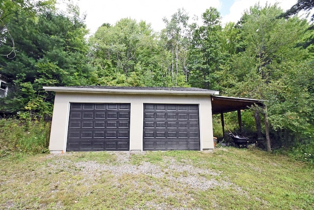 garage featuring a yard and a carport