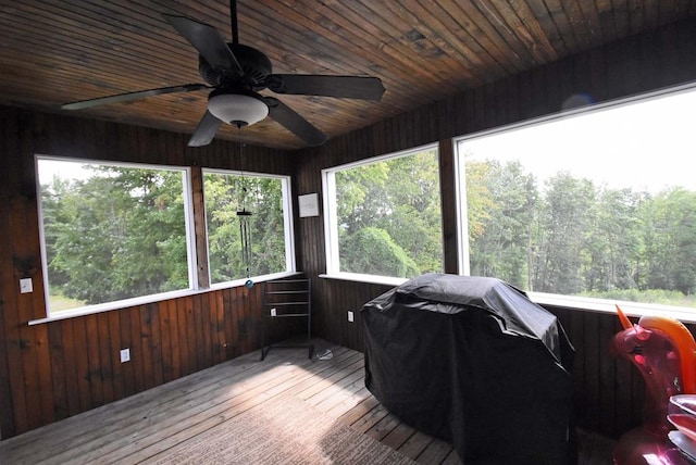 sunroom featuring a healthy amount of sunlight, wooden ceiling, and ceiling fan