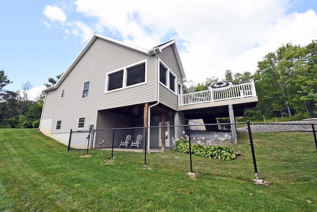 back of property with a wooden deck and a yard