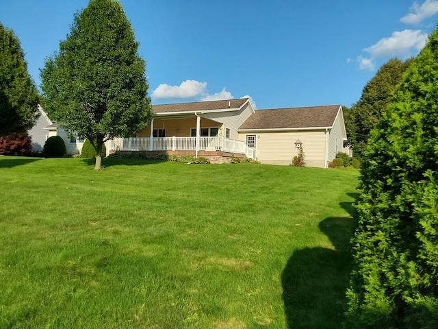 rear view of property featuring a lawn