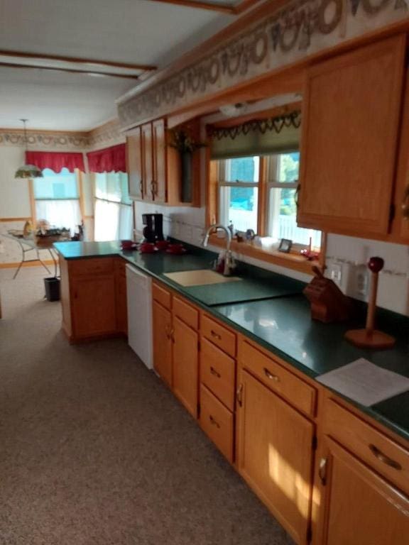 kitchen featuring sink, white dishwasher, and kitchen peninsula