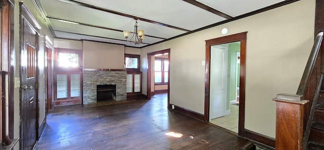 unfurnished living room featuring wood-type flooring, a stone fireplace, crown molding, and an inviting chandelier