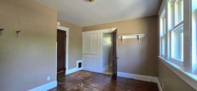 unfurnished bedroom featuring dark wood-type flooring and a closet