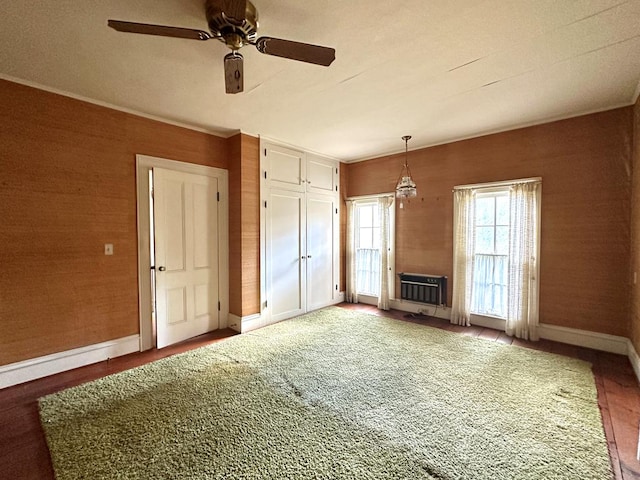 unfurnished living room with ceiling fan and heating unit