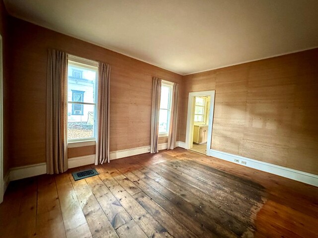 unfurnished room featuring hardwood / wood-style flooring and a healthy amount of sunlight