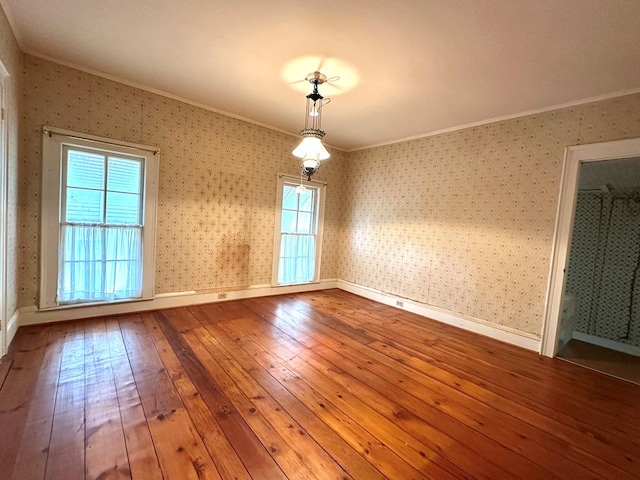 spare room with crown molding and hardwood / wood-style flooring