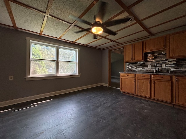 kitchen with backsplash, dark wood-type flooring, sink, and ceiling fan