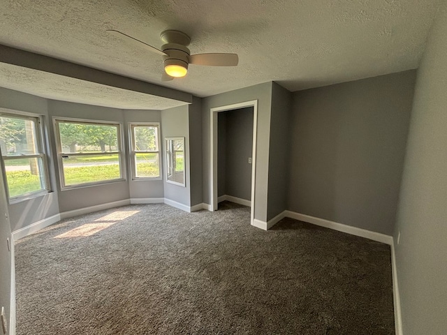 unfurnished bedroom featuring ceiling fan, carpet, and a textured ceiling