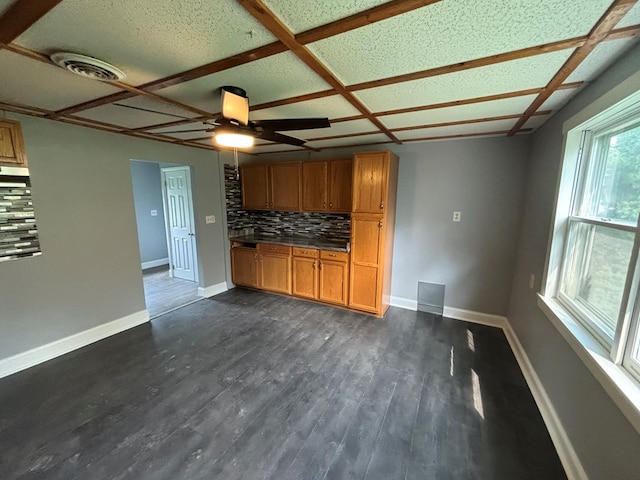 unfurnished living room featuring coffered ceiling, ceiling fan, and dark hardwood / wood-style floors