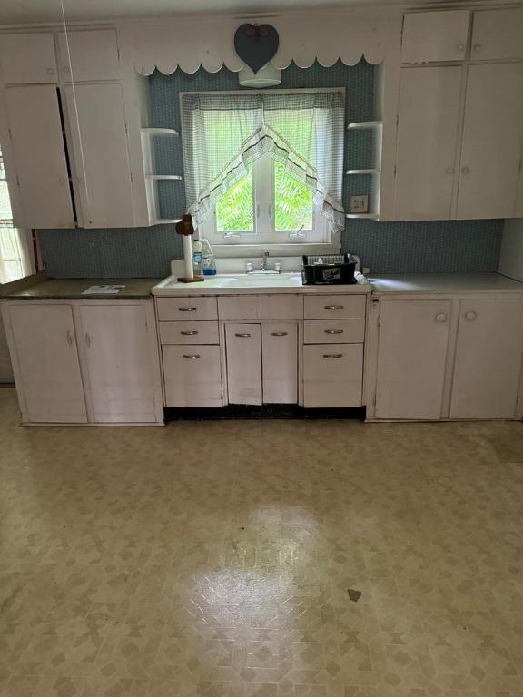 kitchen featuring white cabinetry, sink, and backsplash