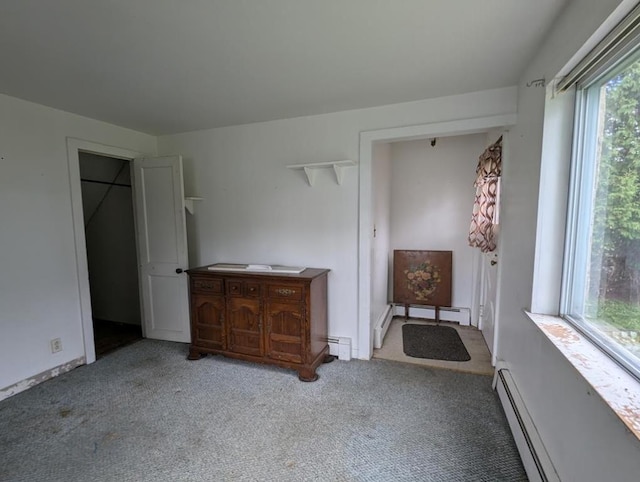 unfurnished bedroom with a baseboard radiator and carpet flooring